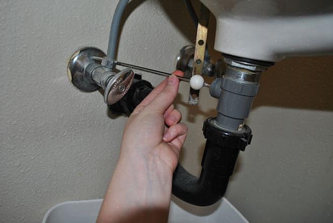 Yksi kylpyhuoneen pesuallasasennuksen vaiheista on vaakasuoran tulppaventtiilin kiinnittäminen